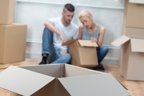 Movers carefully packing household items for relocation